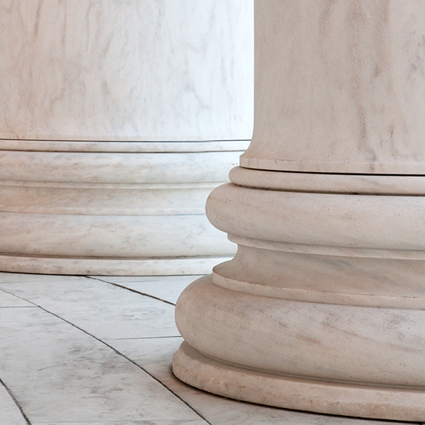 A row of elegant white marble columns supporting the structure of a grand building.